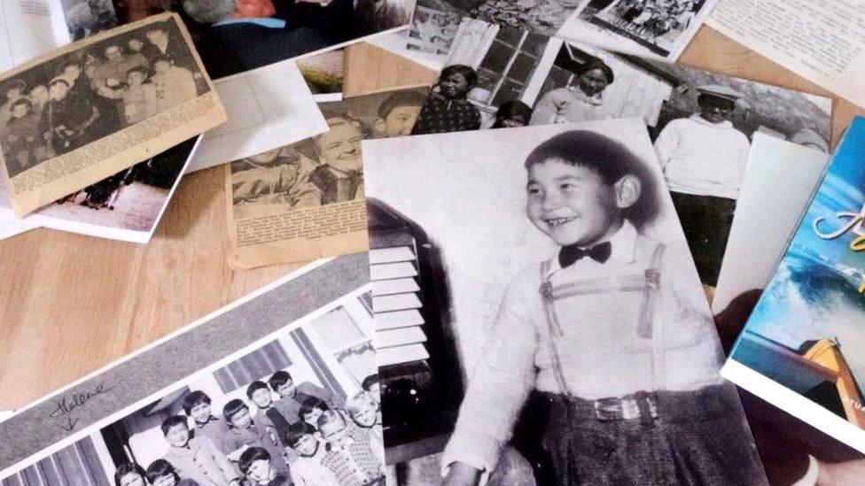 Gabriel Schmidt looks at historic photos strewn across a table