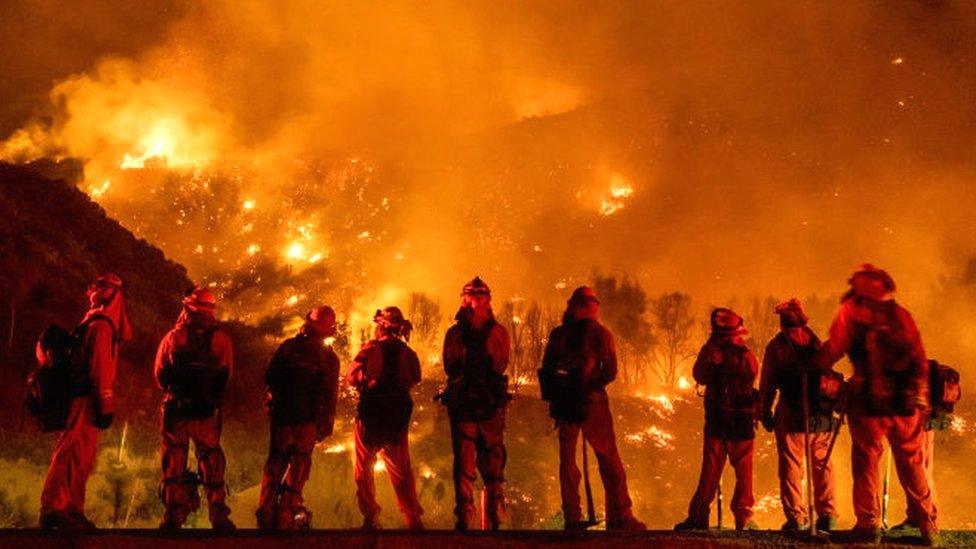 Firefighters watch as the El Dorado blaze burns a hillside near homes in Mountain Home Village, California, inside the San Bernardino National Forest, 9 September 2020