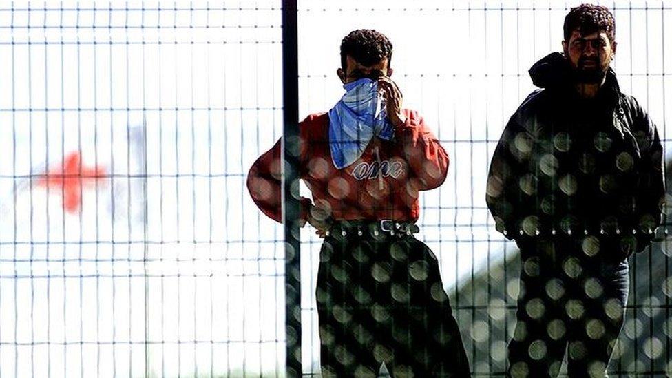 Unidentified refugees stand in the Red Cross refugee camp in Sangatte, northern France, Thursday May 23, 2002.