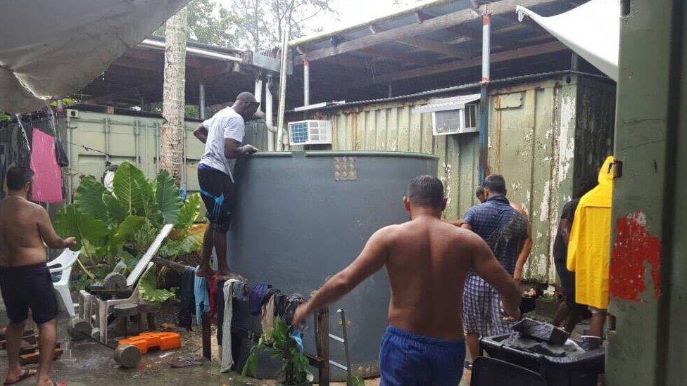 Asylum seekers and detainees at Manus Island around a water tank