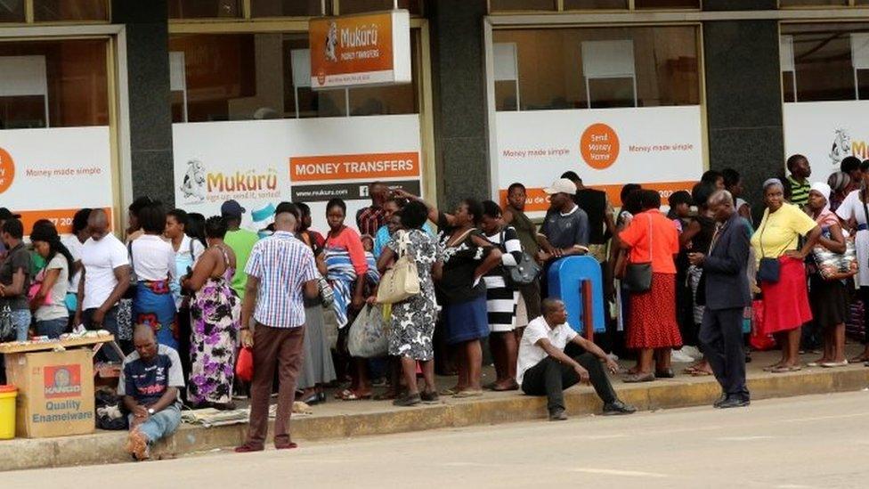 People queue to withdraw money from a bank in Harare (08 March 2017)