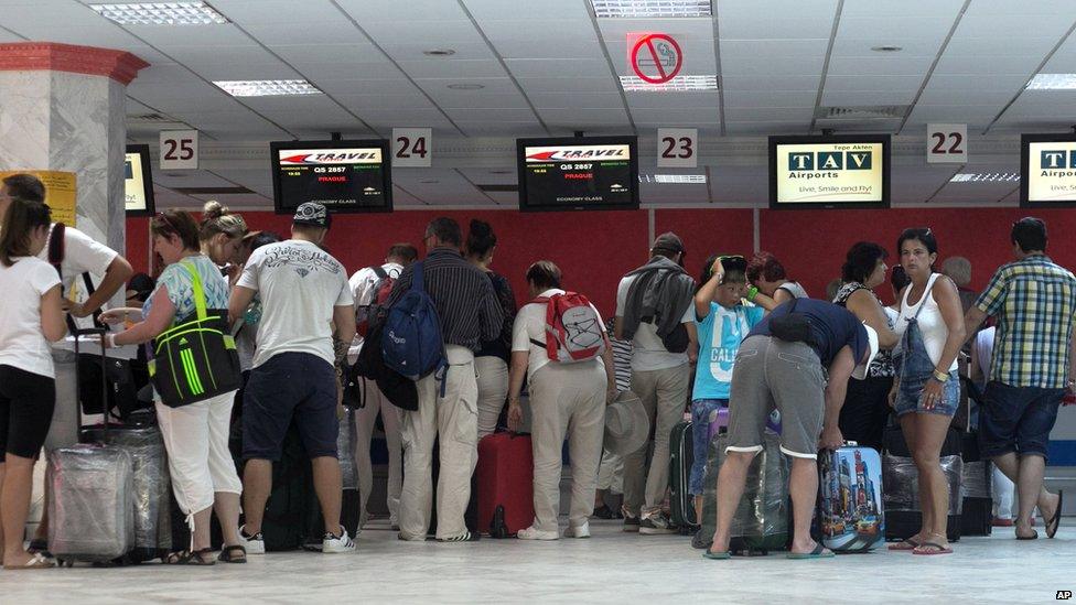 Tourists line up at Monastir airport as they prepare to leave Tunisia on 27 June 2015