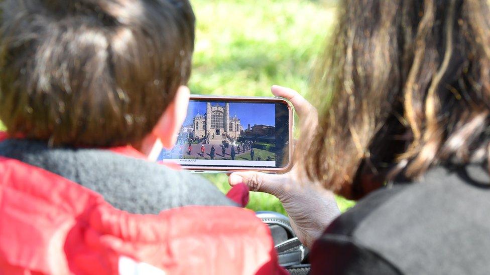 two-children-watching-prince-philip-funeral-on-phone