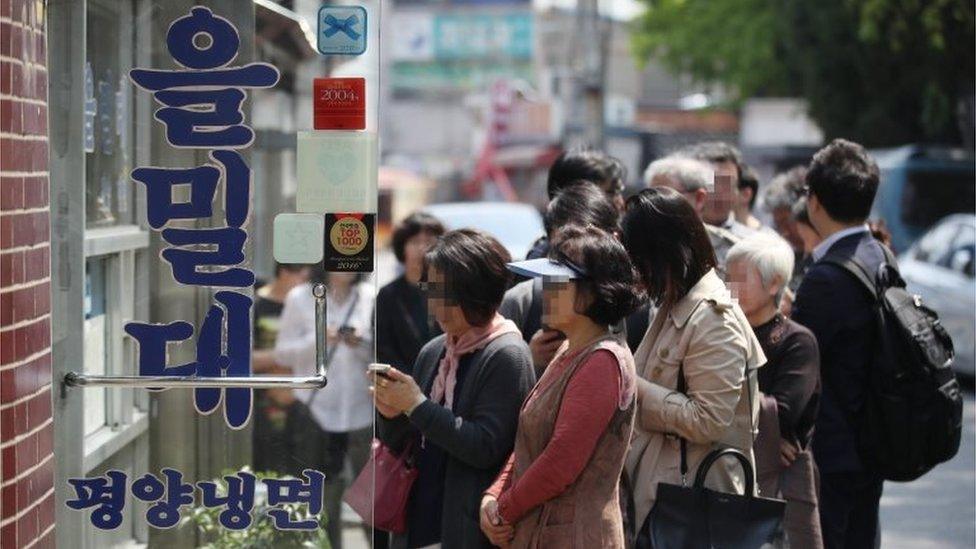 People wait in a long queue to enter a restaurant famous for Pyongyang-style cold noodles, or "naengmyeon" in Korean, in Seoul, South Korea, 27 April 2018