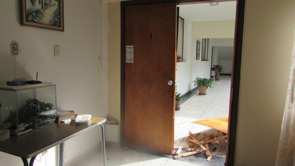 A door lies in pieces at the entrance to a room at the building housing Christian Brothers