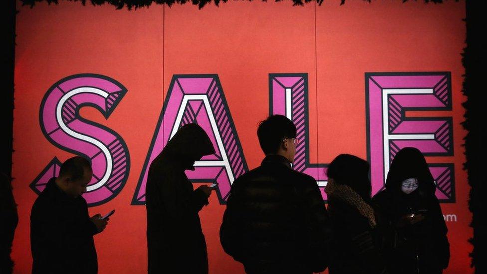 Shoppers standing outside a store front