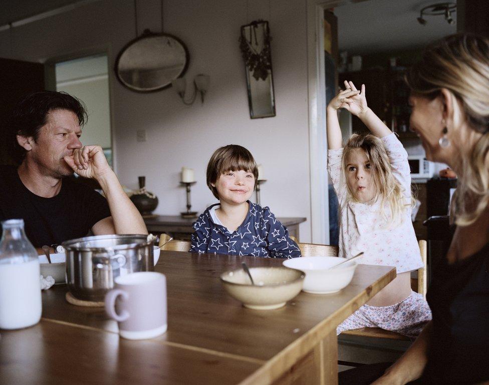 A family sit around the dinner table.