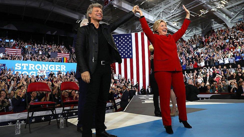 Hillary Clinton with Jon Bon Jovi at rally, in red pantsuit