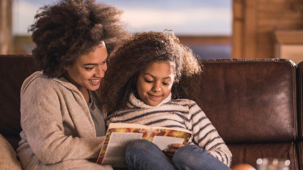 A girl reads to her mum.