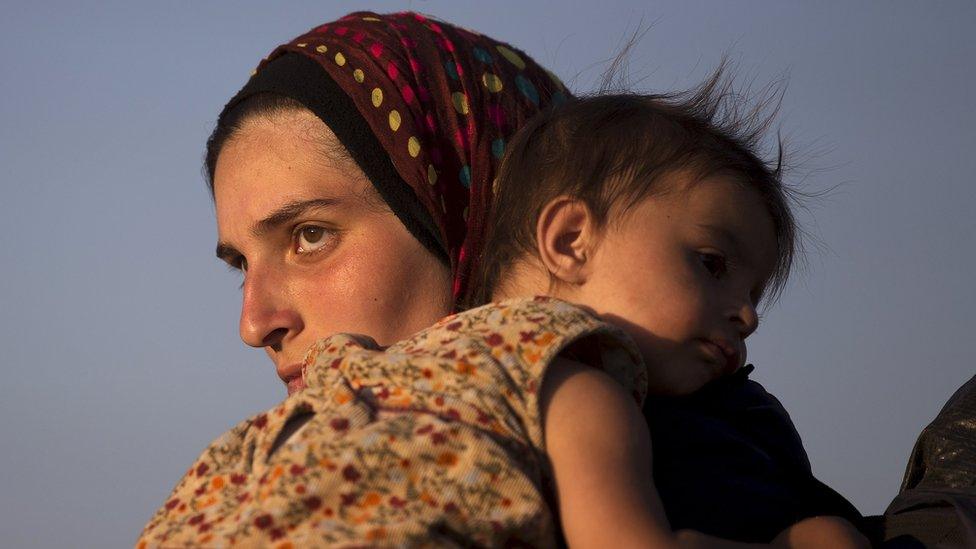 Migrant carries her child after crossing the Macedonian-Greek border (06/09/15)