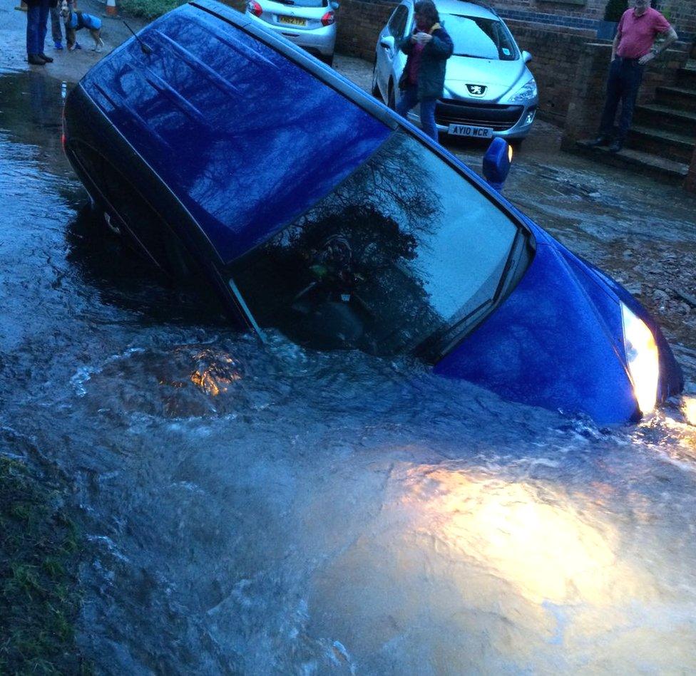 Car in a sinkhole created by a burst water main