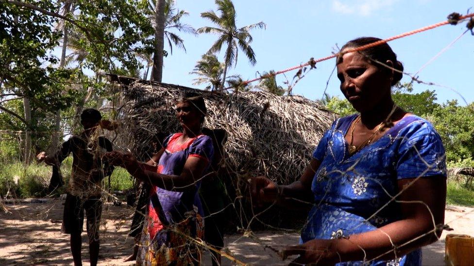 Women hanging fishing nets out to dry