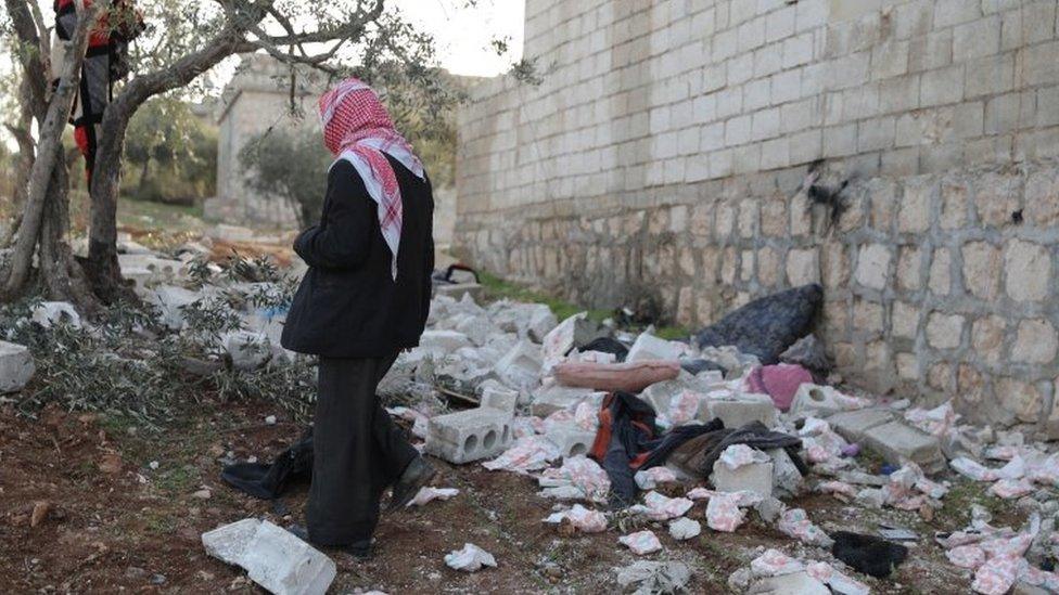 A person inspects the area where the raid happened