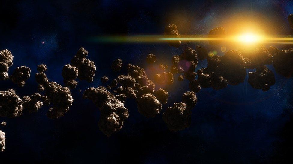 asteroid belt, line of rocks animated image with sun in background