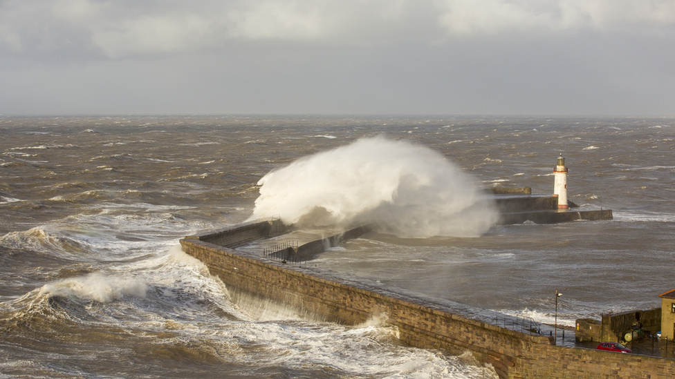 waves crashing on lighthouse