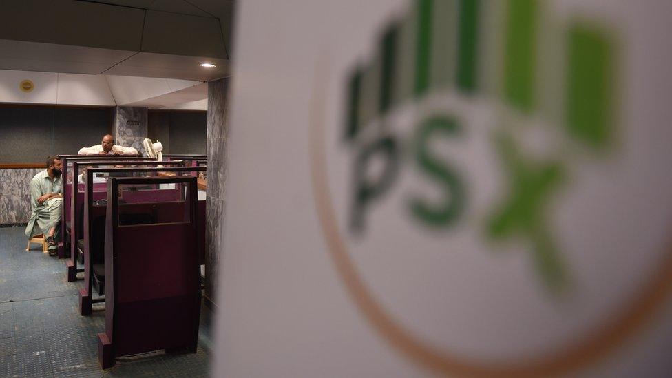 Pakistani stockbrokers monitor shares during a trading at the Pakistan Stock Exchange (PSX) in Karachi