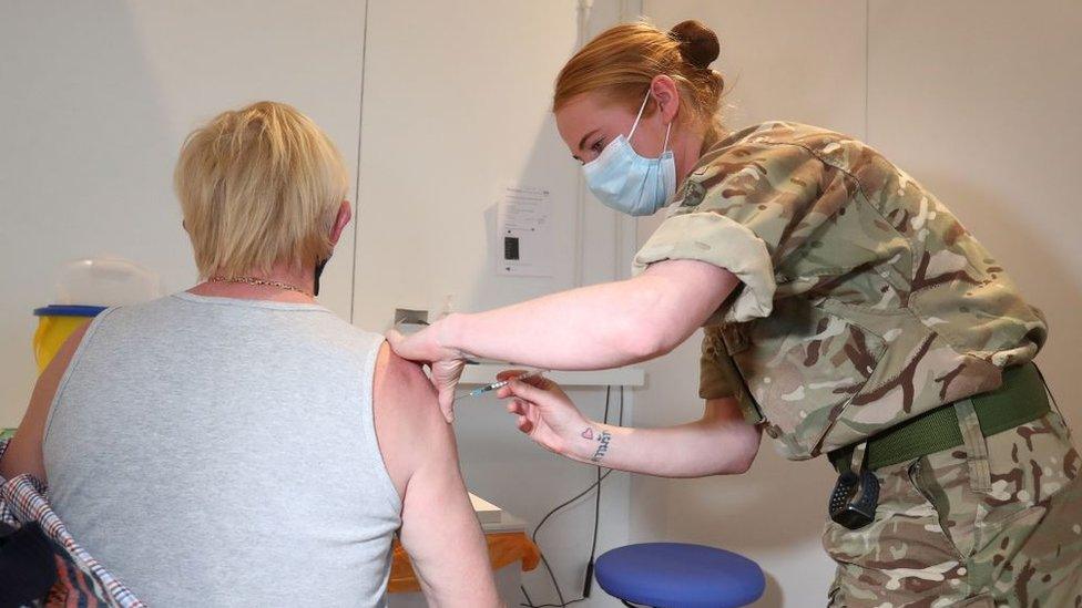 Lance corporal (LCpl) Amy Portman (R) administers a Covid-19 vaccine to Edinburgh resident Michael Maddocks at a temporary vaccination centre set up at the Royal Highland Showground near Edinburgh, Scotland, on February 4, 2021,