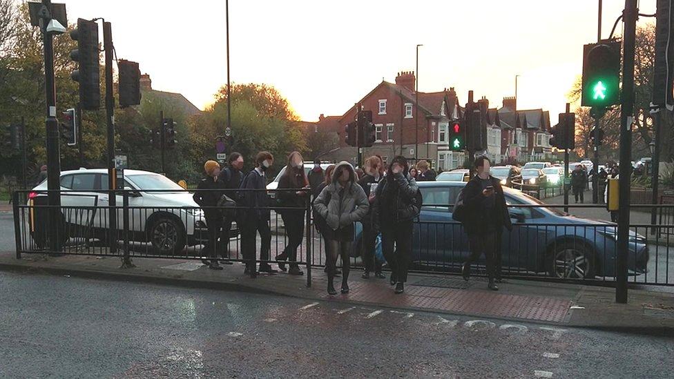 School children crossing the Coast Road on green man, with cars straddling the crossing