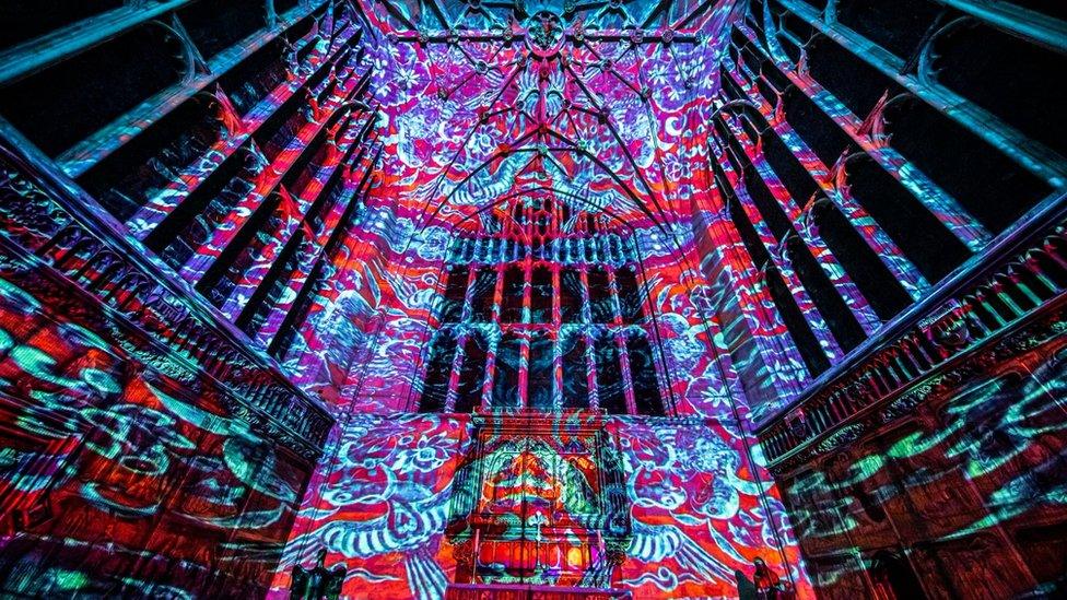 Red and blue prints glowing against the backdrop of the cathedral ceiling