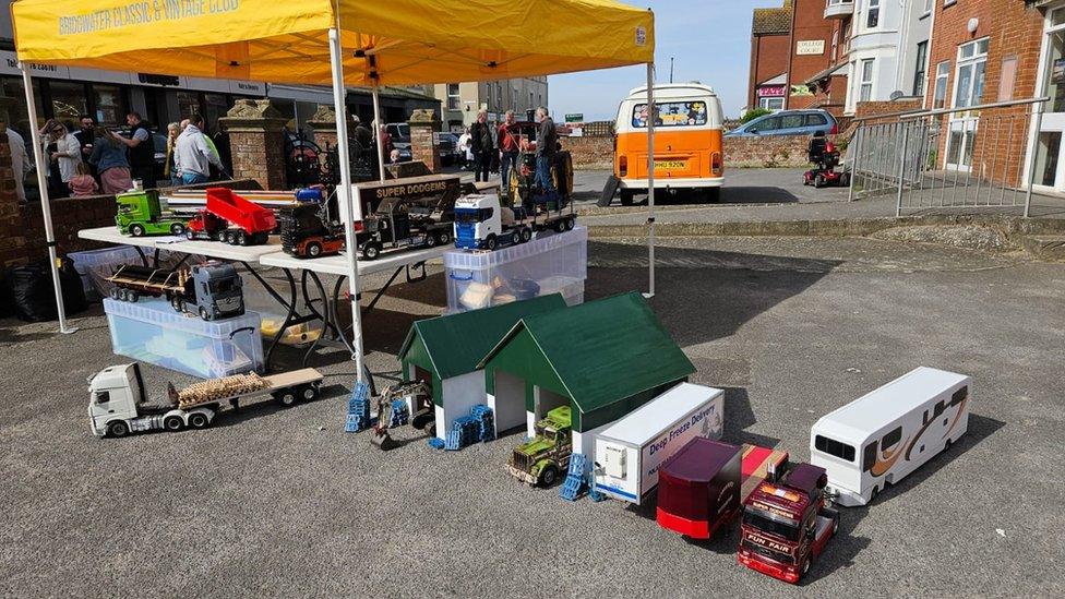 A display of small scale trucks covered by a yellow marquee