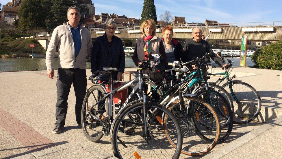 A group of cyclists by the canal in Dole