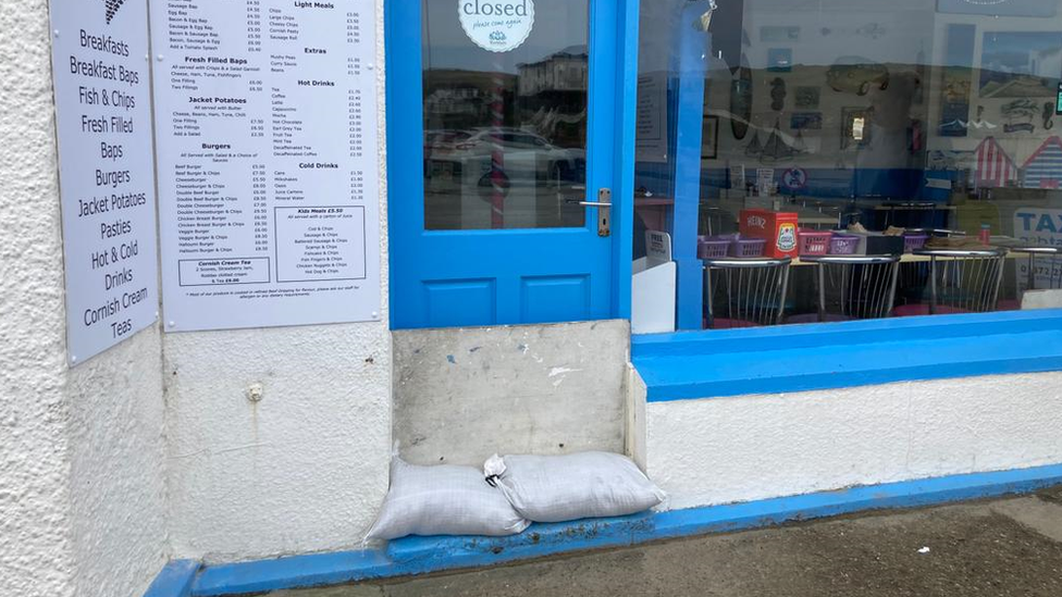 Sandbags and the door boarded in anticipation of flooding