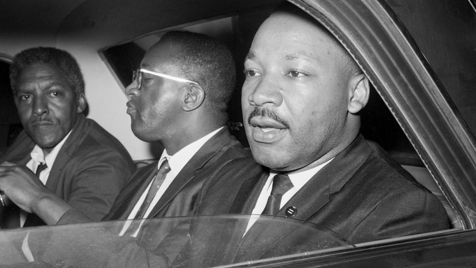 After meeting with New York Mayor Wagner to discuss racial tension in Harlem and Brooklyn, Dr. Martin Luther King, Jr. (r), Bayard Rustin (left), and Rev. Bernard Lee, (c) leave Gracie Mansion. 1964