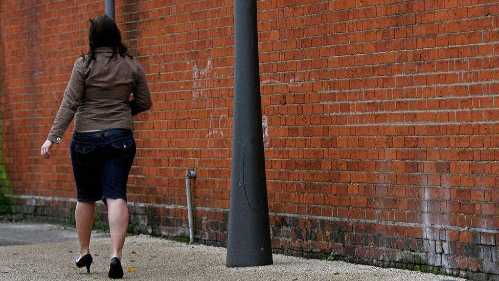 Woman walking in red light district in Suffolk