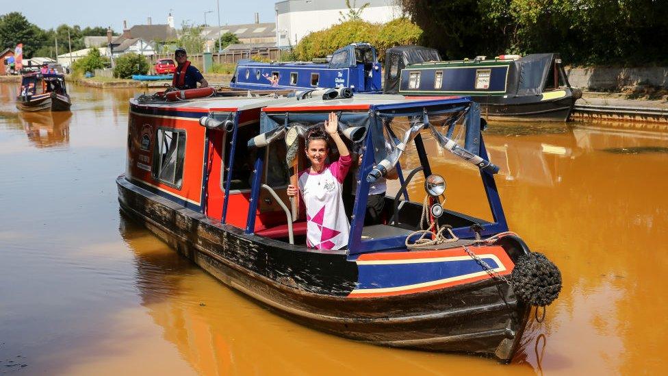 Batonbearer Trudi Beswick holds the Queen's Baton as it visits The Harecastle Tunnel as part of the Birmingham 2022 Queen's Baton Relay on July 18, 2022 in Kidsgrove