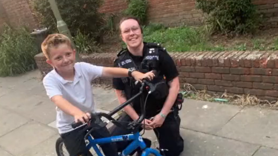 PC Harriett Taylor with boy who lent his bike to officer