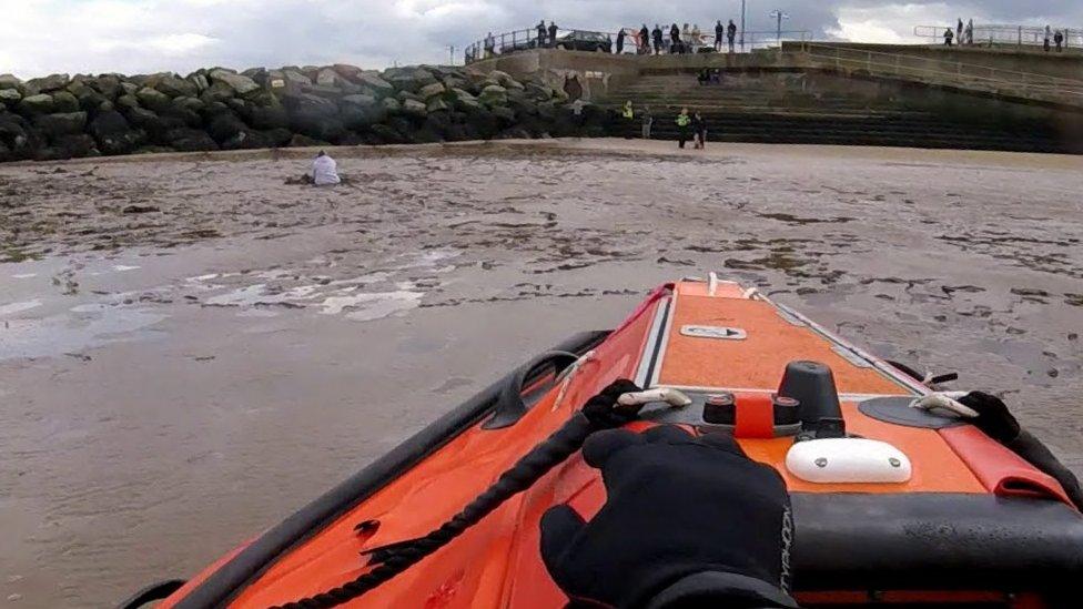 RNLI lifeboat rescuing man stuck in mud