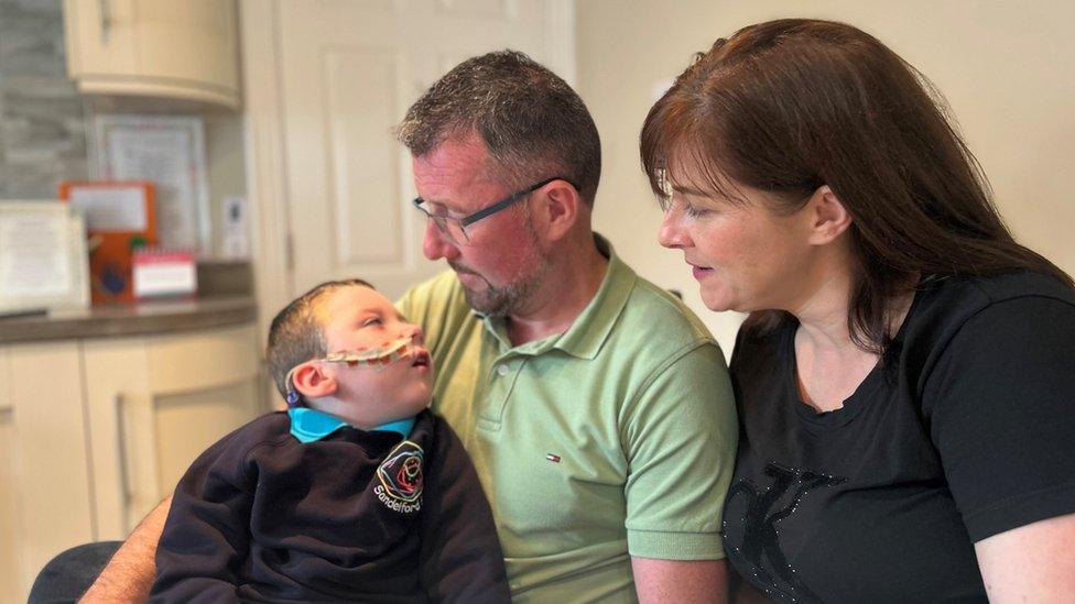 Óisín pictured with his parents at the family home