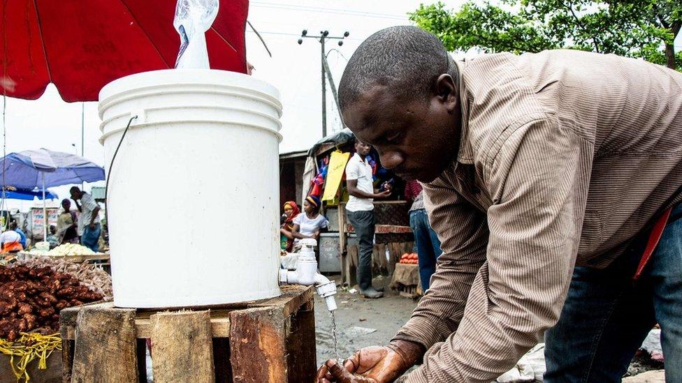 A man washes his hands with chlorinated water at the Mabibo market in Dar es Salaam, Tanzania, on April 16, 2020