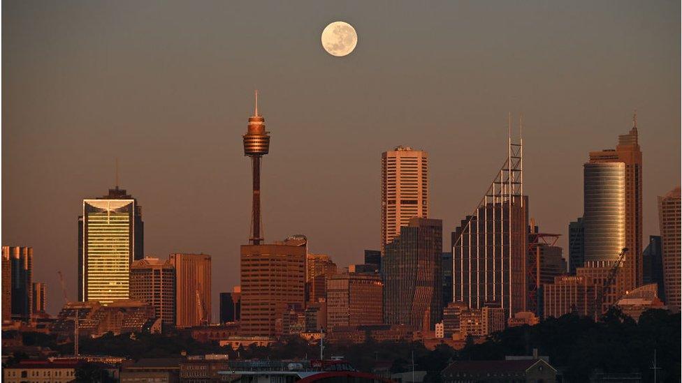 The strawberry moon seen over the skyline of Sydney in Australia.