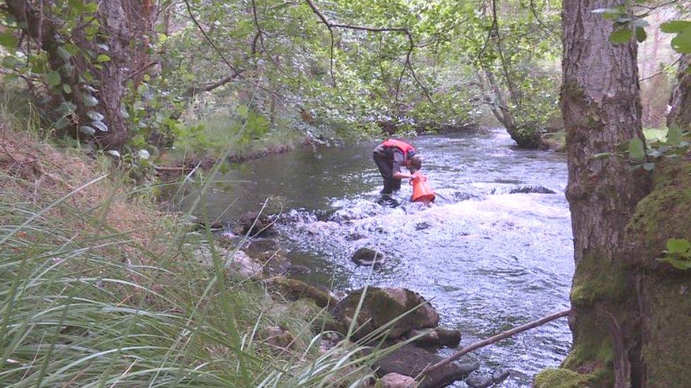 Kieran using equipment to look for mussels