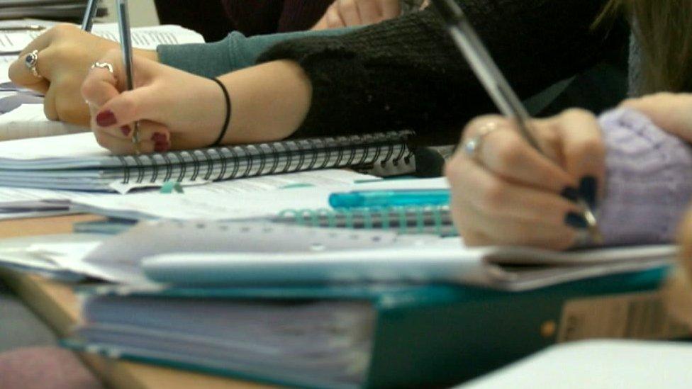 Students writing at a lecture