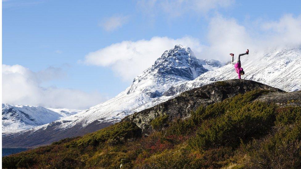 An image made available on 20 March 2017 showing a girl standing on hands with the Torfinnstind Jotunheimen in the background, Vang, Norway, 01 October 2016.