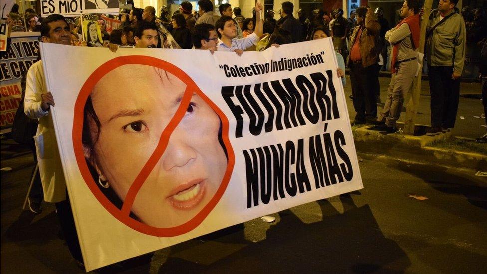 People attend a march against Keiko Fujimori carrying a sign reading "Fujimori never again"