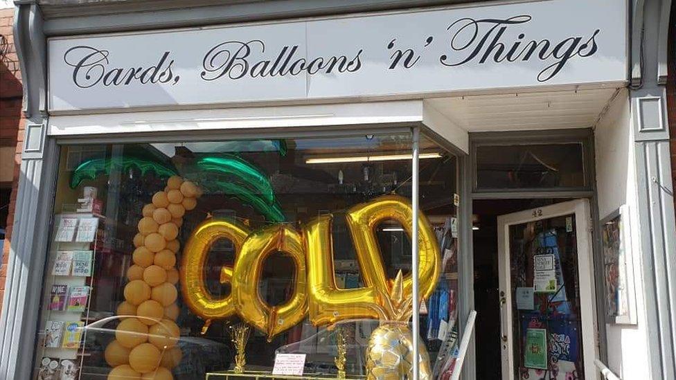 Shop front decorated with gold balloons