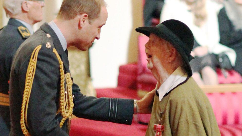 Hughes alongside the Duke of Cambridge at Buckingham Palace in 2017