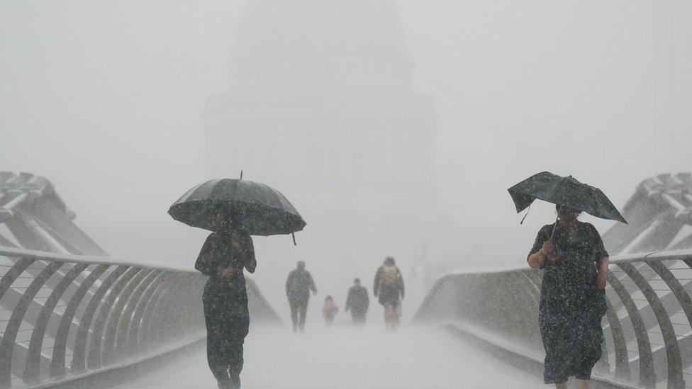 People walking in the rain on Millennium Bridge