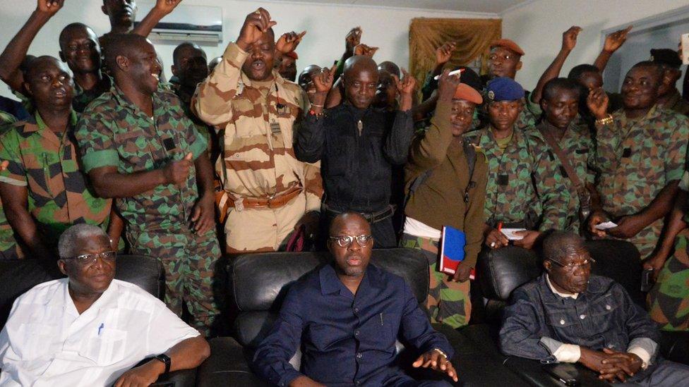 A delegation of mutinous soldiers stand behind Ivory Coast"s defence minister Alain-Richard Donwahi (C-front) speaking to journalists after negotiations, on January 7, 2017 in Bouake.