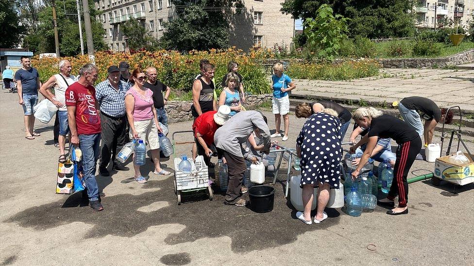 People queue to access drinking water in the Ukrainian town Marhanets