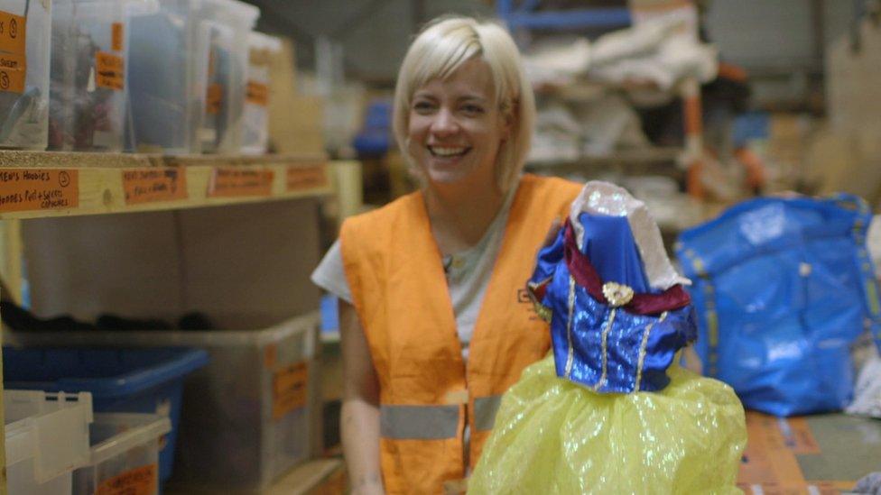 Lily Allen holds a Snow White dress donated by her children