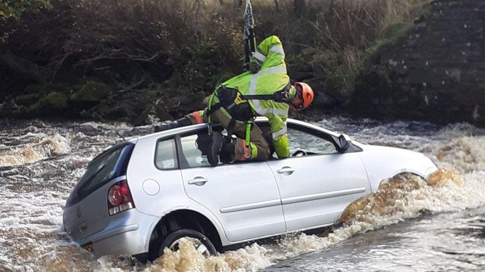 Firefighter rescuing occupant of car