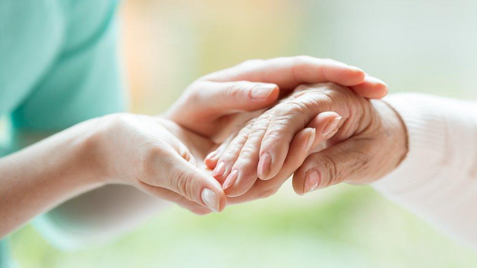 Nurse and patient holding hands