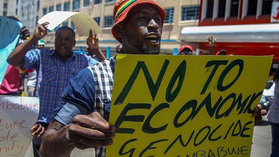 A protester holds a sign during a demonstration by opposition parties against the introduction of bond notes as a currency in Harare on November 30 2016