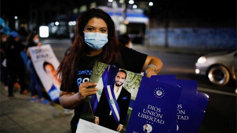 A supporter of the Nuevas Ideas political party holds calendars with the picture of El Salvador's President Nayib Bukele as she takes part in a rally during the last day of election campaign in San Salvador, El Salvador, February 24, 2021