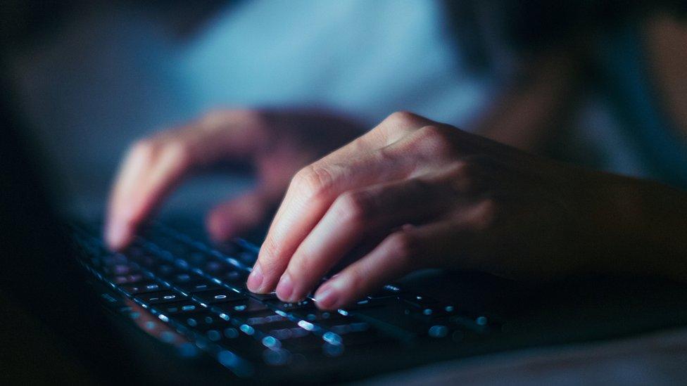 Hands typing on a keyboard