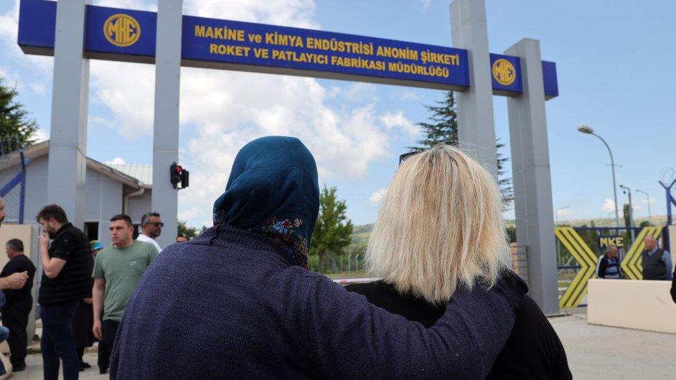 Families wait for news outside the factory